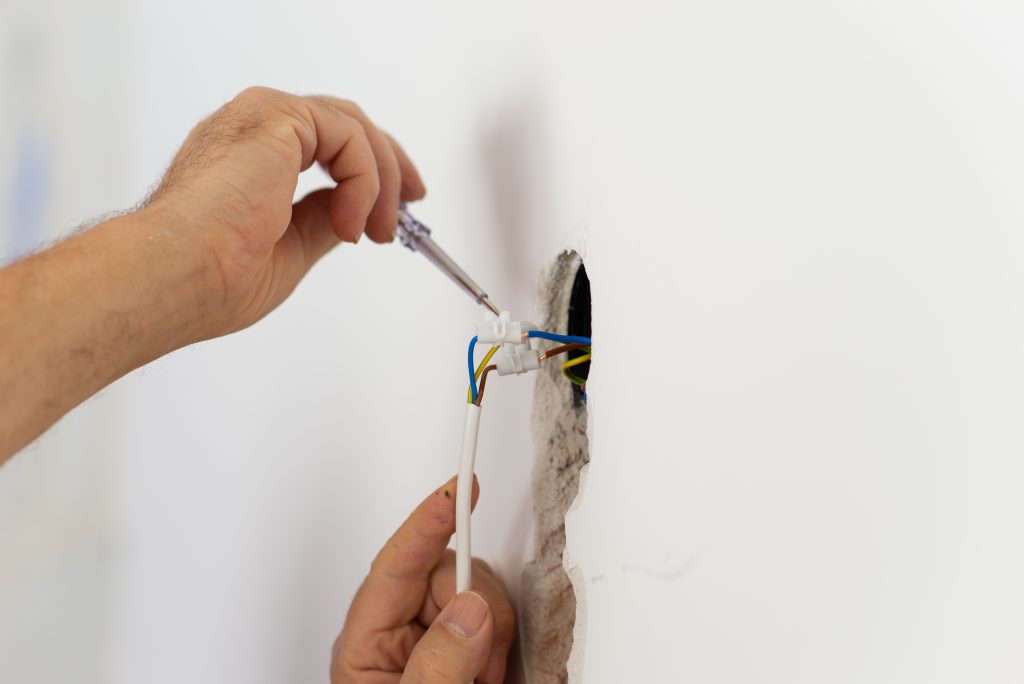 Electrician checking the presence of electrical current in a wir